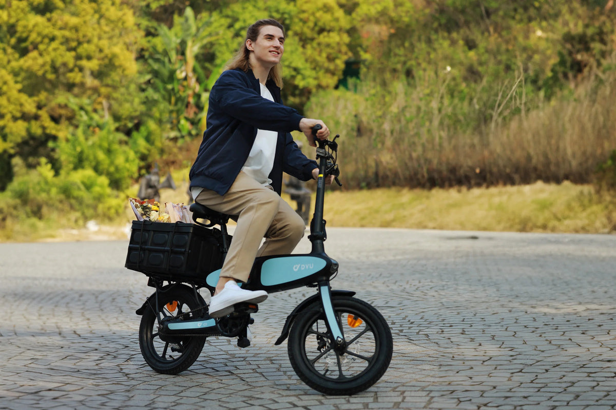 Uomo alla guida della bici elettrica pieghevole DYU C2 su un vialetto