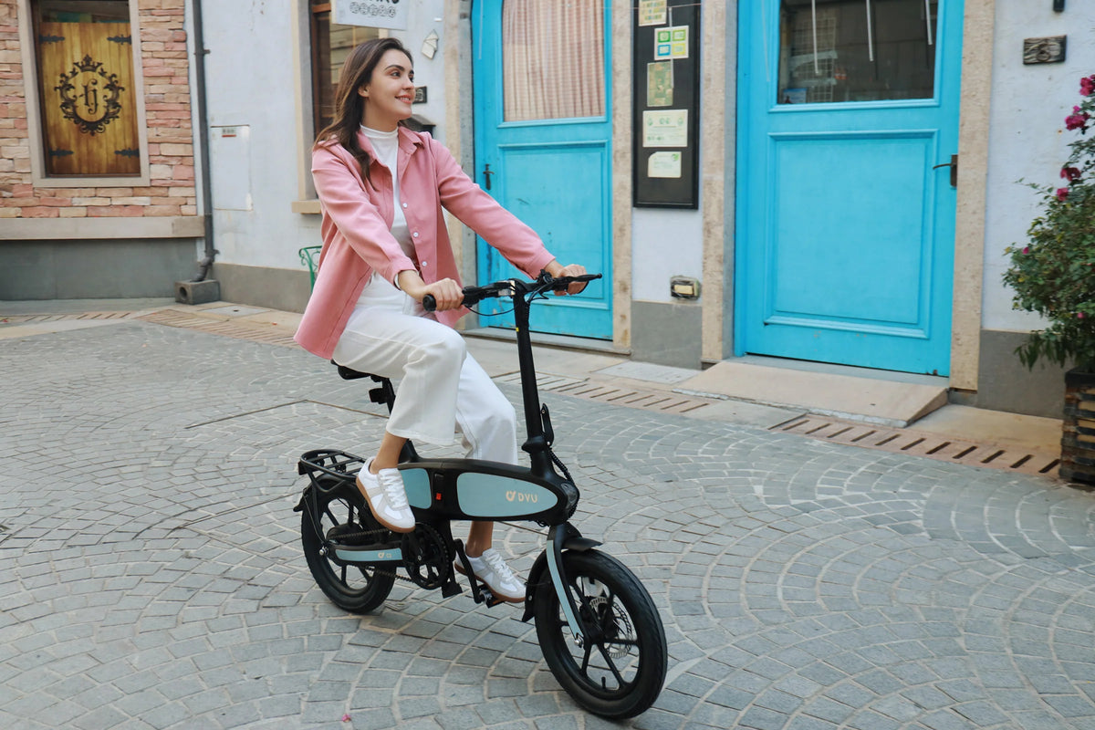 Donna alla guida della bici elettrica pieghevole DYU C2 in città