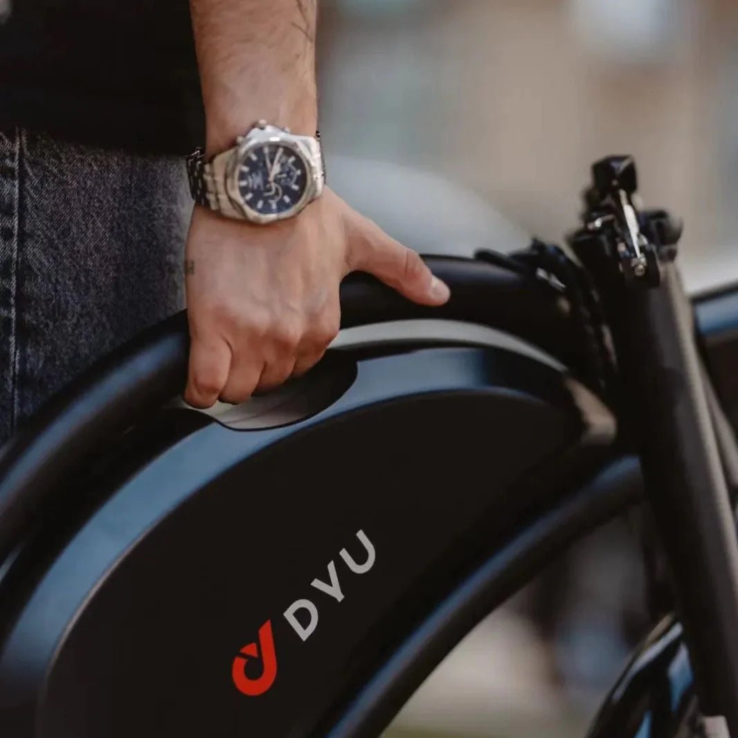 Persona che porta la bici elettrica pieghevole DYU D3S piegata