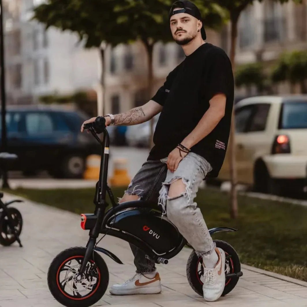 Uomo in piedi con la bici elettrica pieghevole DYU D3S in città