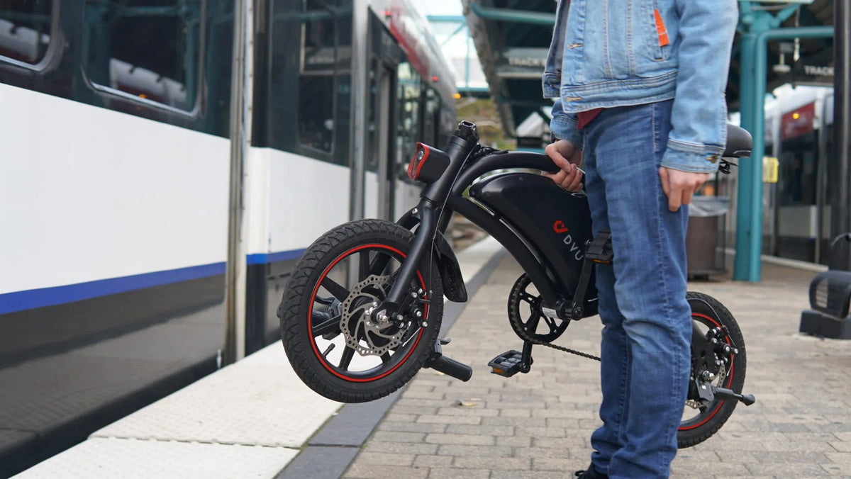 Uomo in piedi con la bici elettrica pieghevole DYU D3S in città