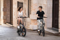Due persone con la bici elettrica pieghevole DYU T1 in città