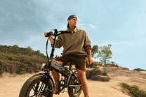 Uomo in piedi con la fat bike elettrica pieghevole ENGWE ENGINE X su un prato