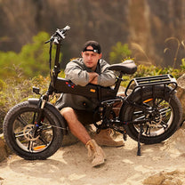 Uomo in piedi con la fat bike elettrica pieghevole ENGWE ENGINE X su terreno sabbioso