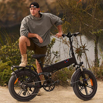 Uomo in piedi con la fat bike elettrica pieghevole ENGWE ENGINE X su terreno sabbioso