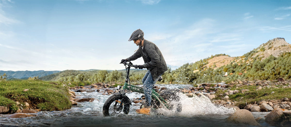 Uomo alla guida della fat bike elettrica pieghevole ENGWE EP-2 3.0 Boost su un prato
