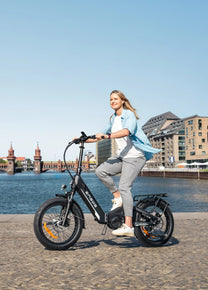 Donna alla guida della bici elettrica pieghevole ENGWE L20 3.0 Pro in città