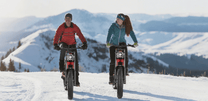 Due persone con la fat bike elettrica Hidoes B6 sulla neve