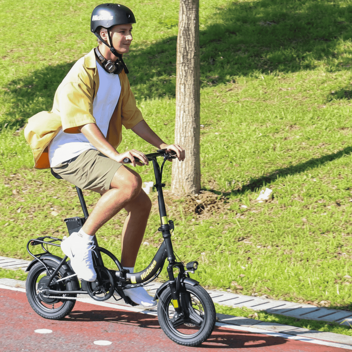 Uomo alla guida della bici elettrica pieghevole Hidoes C5 in un parco