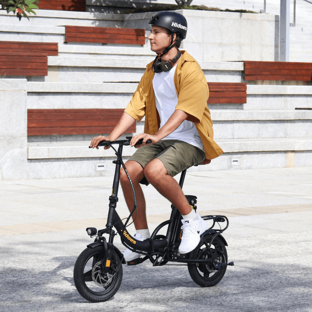 Uomo alla guida della bici elettrica pieghevole Hidoes C5 in città