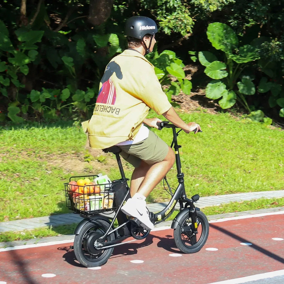 Uomo alla guida della bici elettrica pieghevole Hidoes C5 in un parco