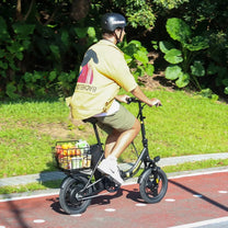 Uomo alla guida della bici elettrica pieghevole Hidoes C5 in un parco