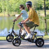 Due persone con la bici elettrica pieghevole Hidoes C5 in un parco