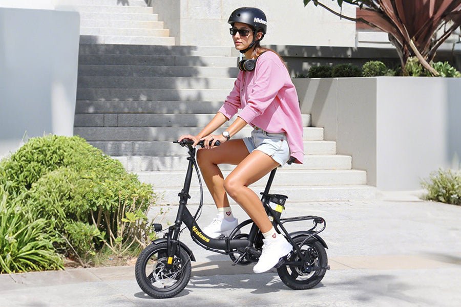 Donna alla guida della bici elettrica pieghevole Hidoes C5 in città