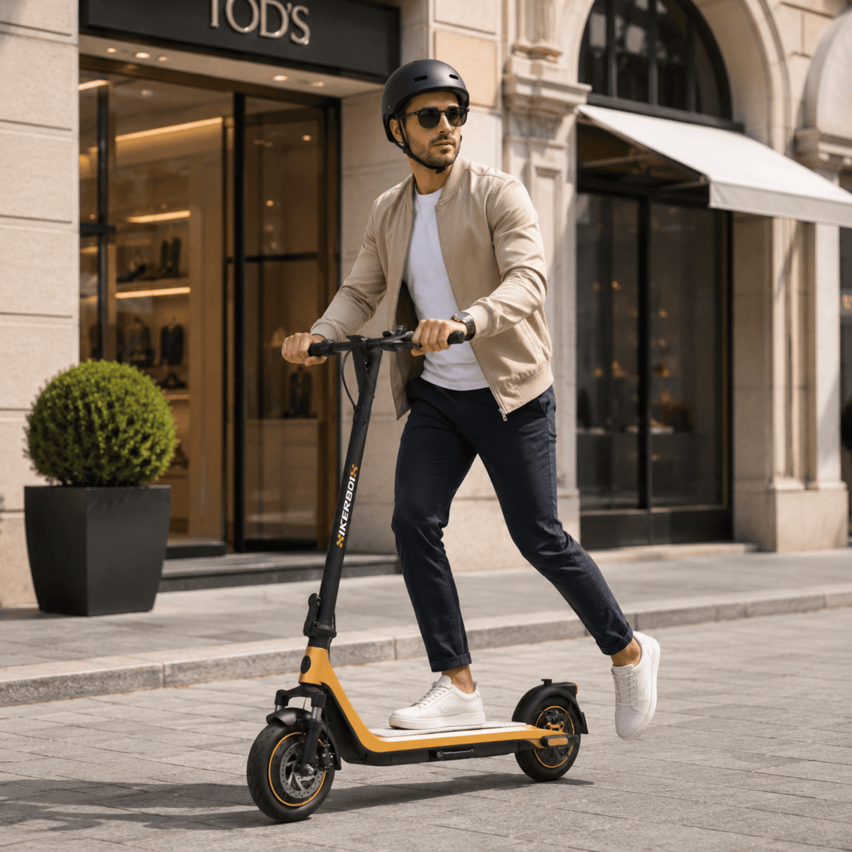 Uomo che passeggia con il monopattino elettrico HIKERBOY CURTIS DUAL PRO in una strada