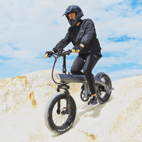 Uomo alla guida della fat bike elettrica HX Q3 Plus su terreno sabbioso