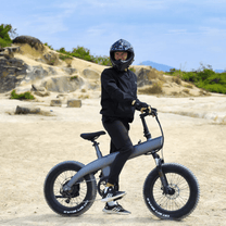 Uomo in piedi con la fat bike elettrica HX Q3 Plus su terreno sabbioso