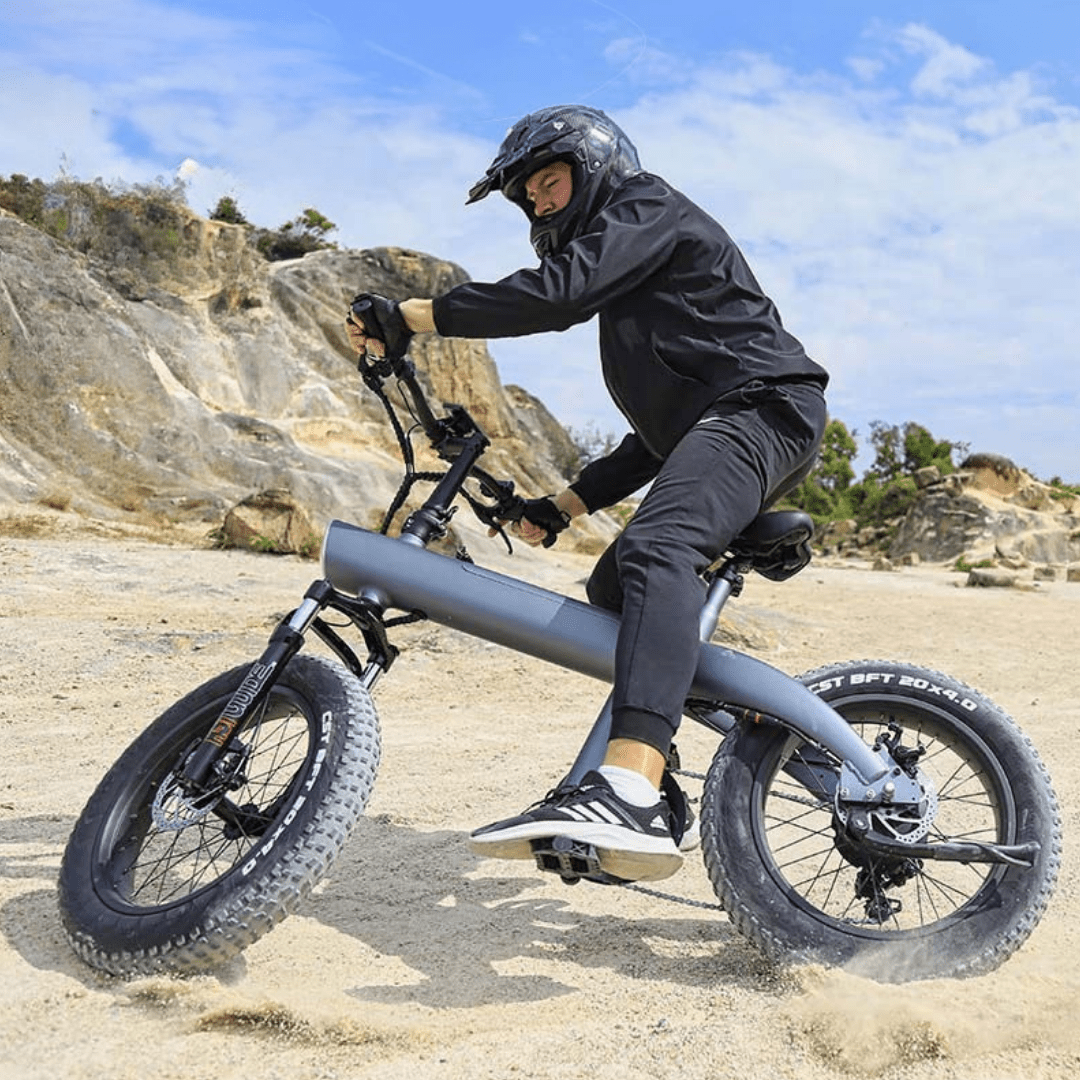 Uomo alla guida della fat bike elettrica HX Q3 Plus su terreno sabbioso