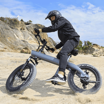 Uomo alla guida della fat bike elettrica HX Q3 Plus su terreno sabbioso