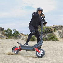 Uomo alla guida del monopattino elettrico HX X10 su terreno sabbioso