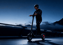 Uomo alla guida del monopattino elettrico HX X9B in un ambiente serale