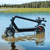 Monopattino elettrico HX X9B piegato in riva a un lago