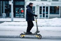 Uomo alla guida del monopattino elettrico iENYRID ES1 sulla neve