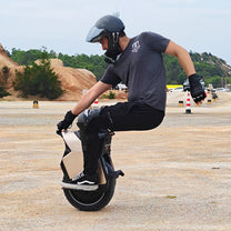 Uomo alla guida del monociclo elettrico InMotion V12S su terreno sabbioso
