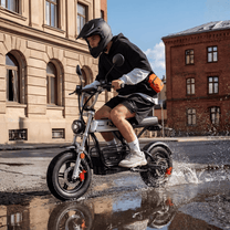 Persona alla guida della moto da cross elettrica iScooter DX5 Pro in città in un ambiente serale