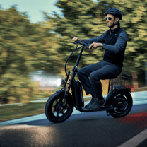Persona alla guida del monopattino elettrico iScooter F7 in città nel bosco