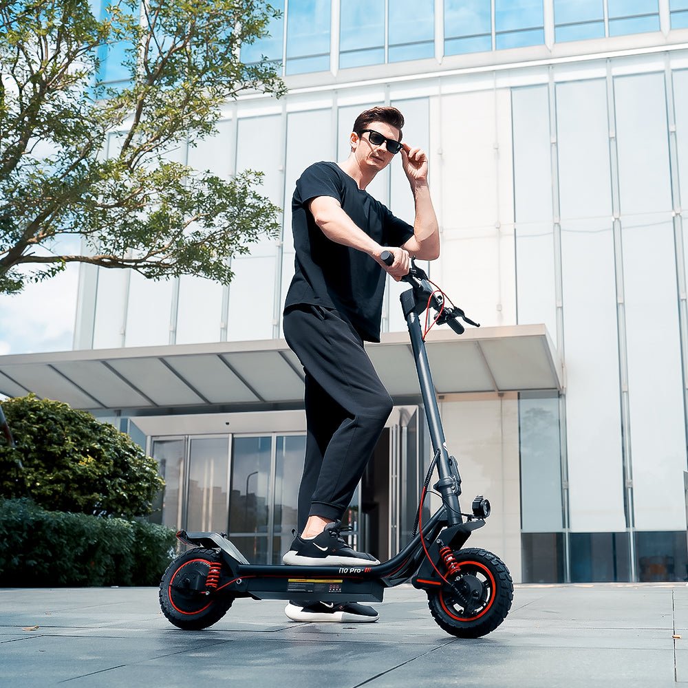 Persona in piedi con il monopattino elettrico iScooter i10 Pro su un vialetto