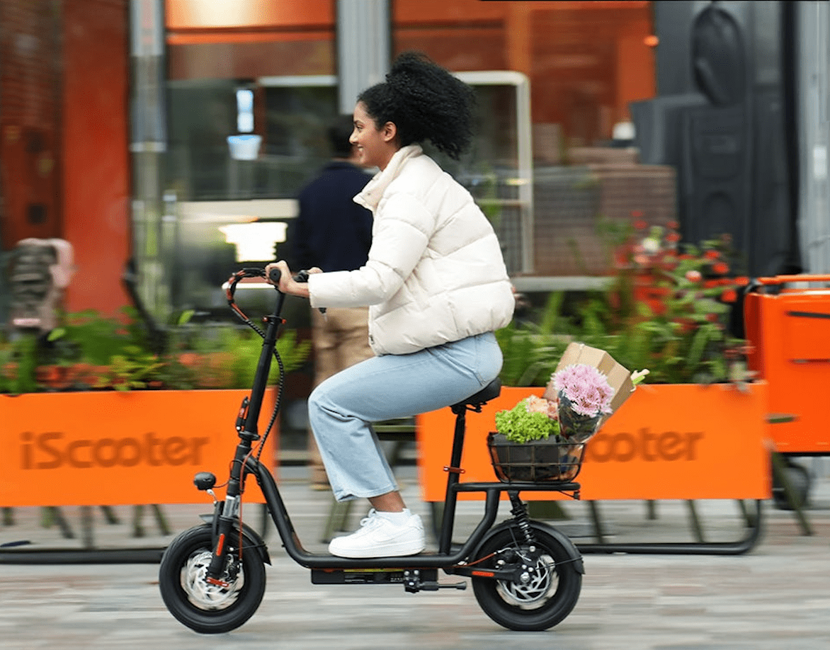 Donna alla guida del monopattino elettrico iScooter i12 in città
