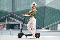 Donna alla guida del monopattino elettrico iScooter W6 in città