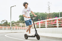 Persona alla guida del monopattino elettrico iScooter W6 in città