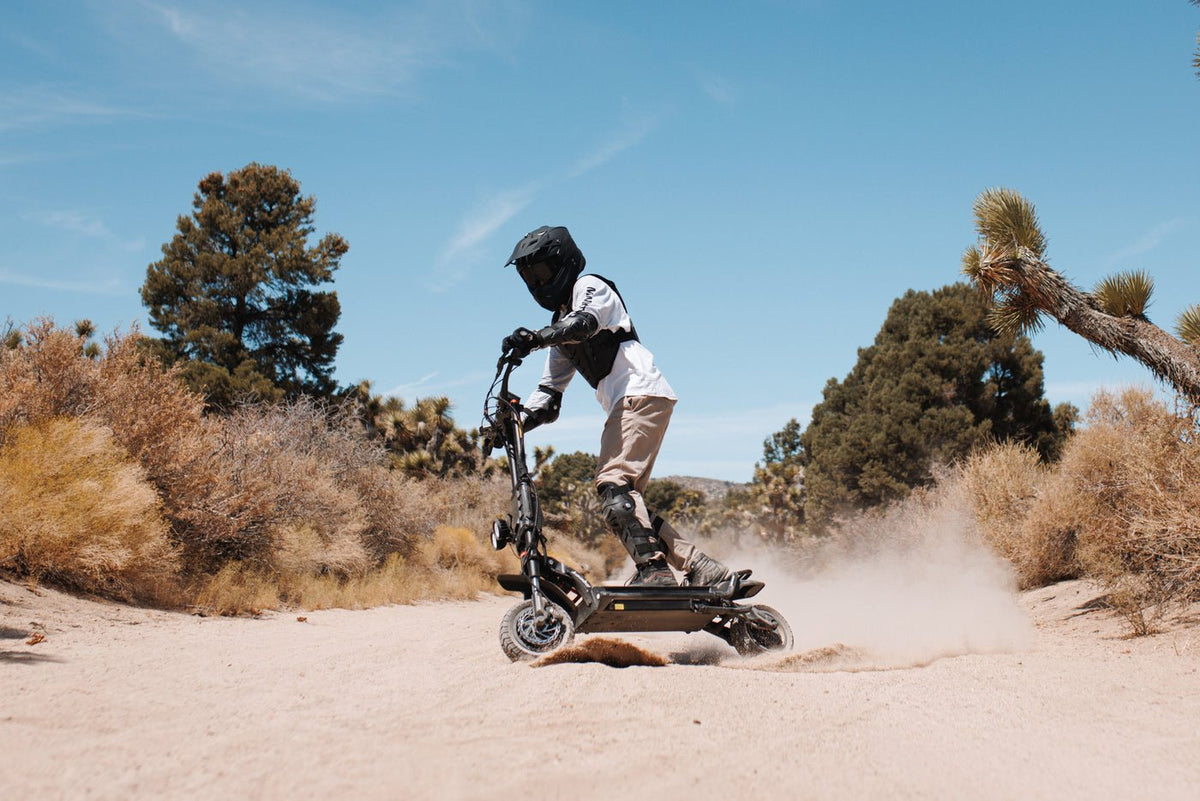 Persona alla guida del monopattino elettrico KAABO WOLF KING GTR MAX nel deserto