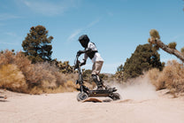 Persona alla guida del monopattino elettrico KAABO WOLF KING GTR MAX nel deserto