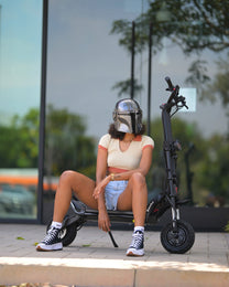 Persona seduta accanto al monopattino elettrico KAABO WOLF WARRIOR 11 MAX