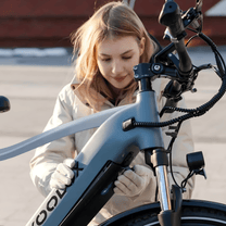 Donna in piedi con la bici elettrica KOOLUX X3 in città