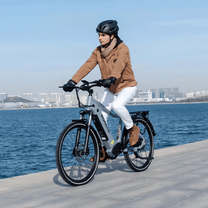 Uomo alla guida della bici elettrica KOOLUX X3 in riva al mare