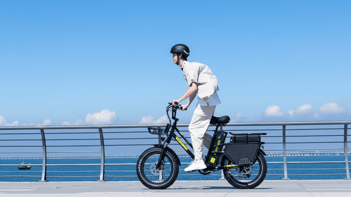 Uomo alla guida della fat bike elettrica KOOLUX X8 in riva al mare