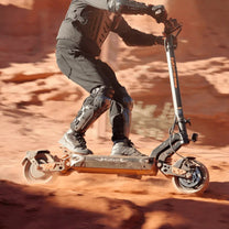 Pilota con il monopattino elettrico KuKirin G2 Master in fuoristrada su terreno sabbioso