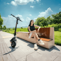 Persona seduta accanto al monopattino elettrico KuKirin G2 VMP