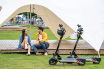 Persona seduta accanto al monopattino elettrico KuKirin M4 Max in un parco