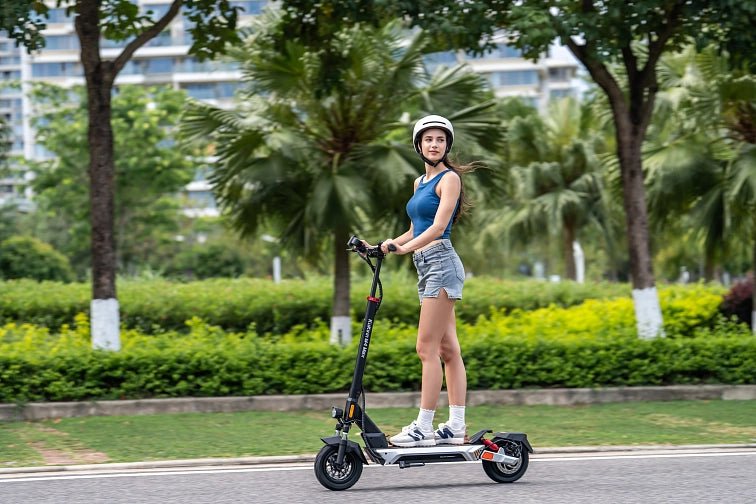 Donna alla guida del monopattino elettrico KuKirin M4 Max in città