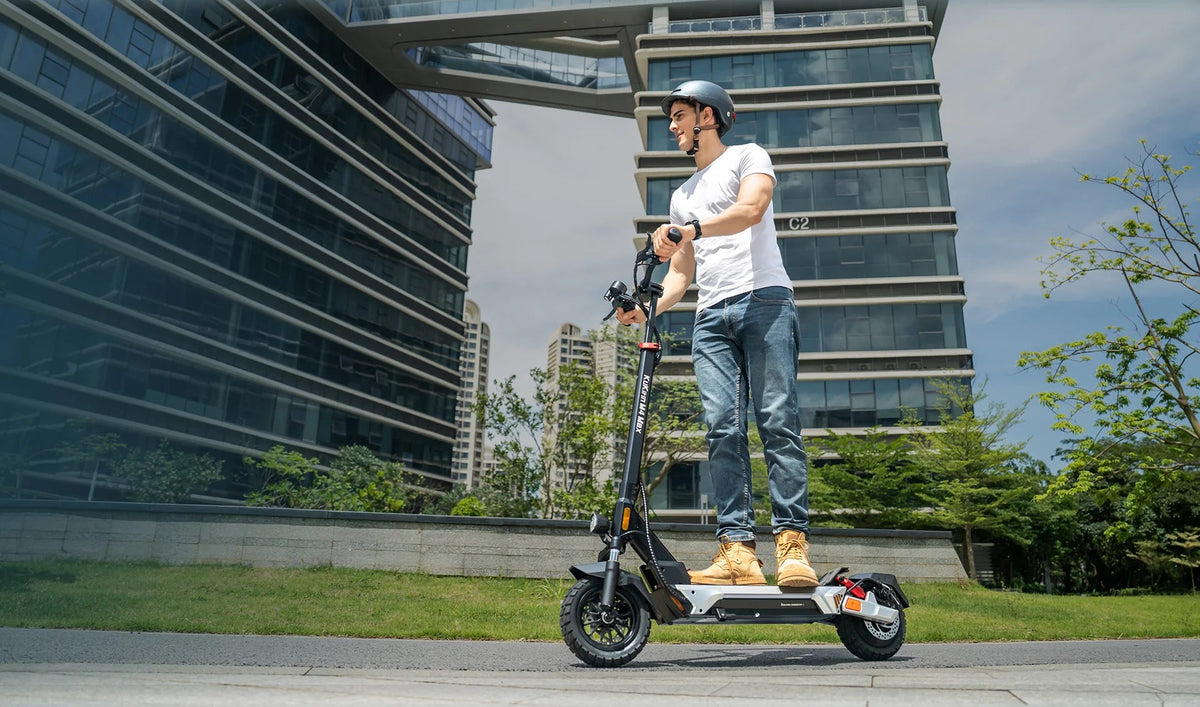 Persona alla guida del monopattino elettrico KuKirin M4 Max in città