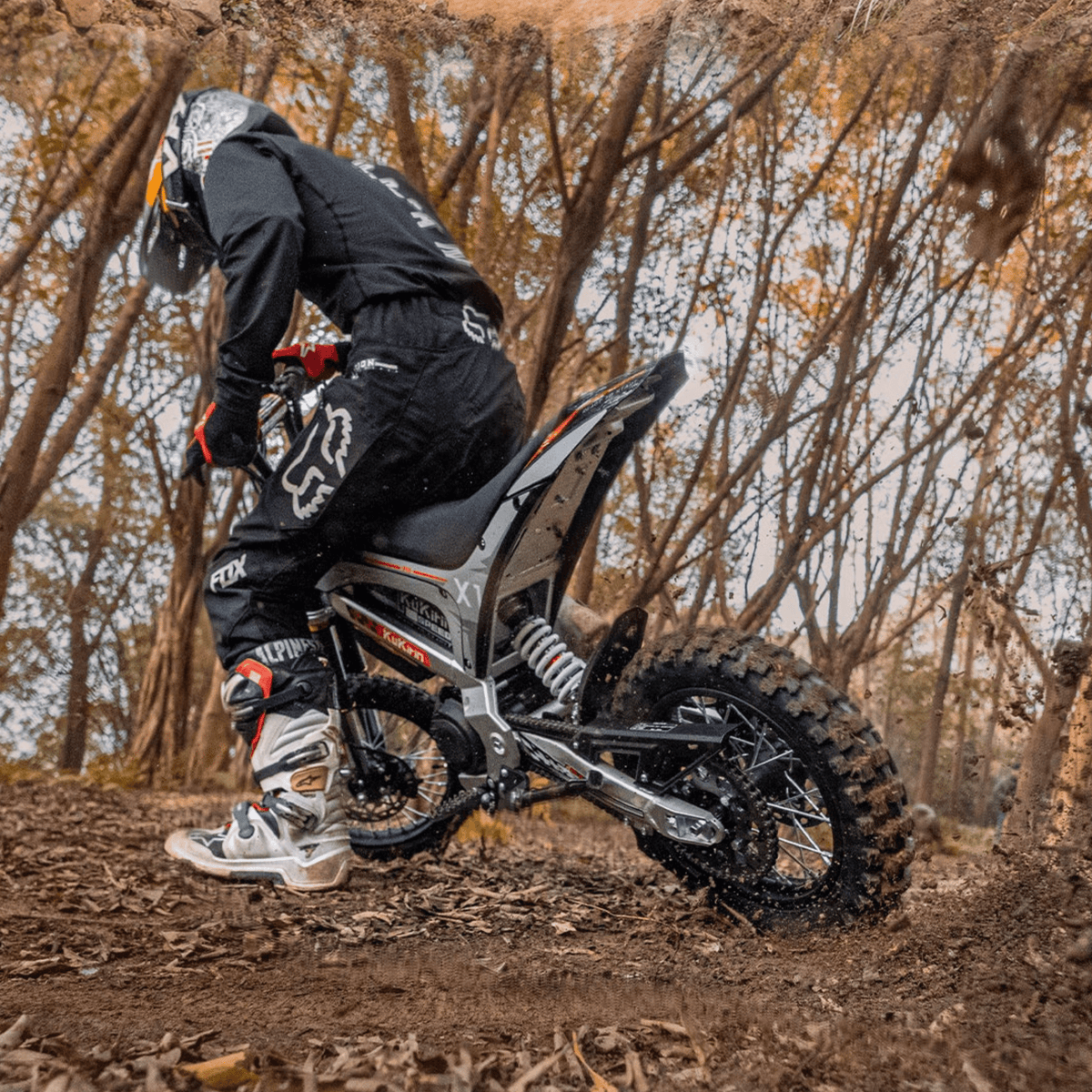 Pilota con la moto da cross elettrica KuKirin X1 in fuoristrada nel bosco
