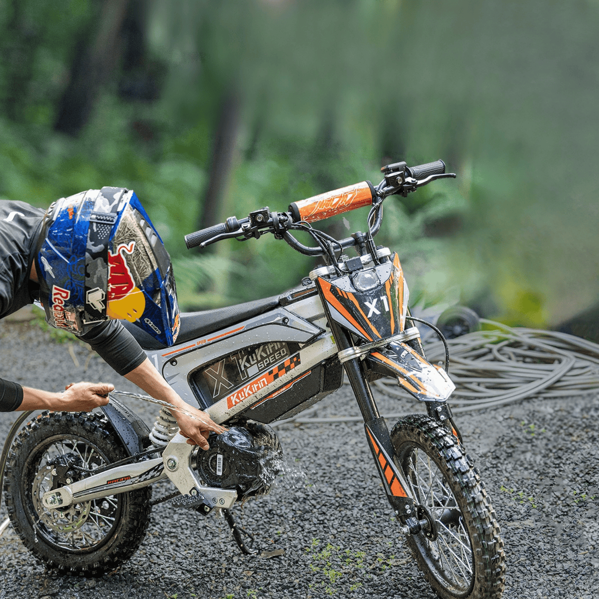 Persona in piedi con la moto da cross elettrica KuKirin X1 nel bosco