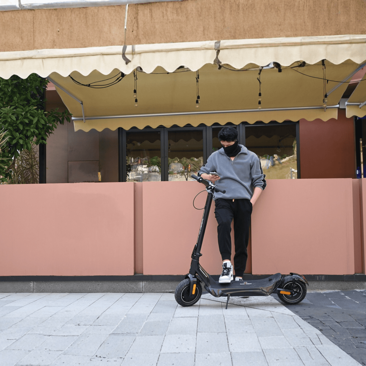 Uomo in piedi con il monopattino elettrico Nanrobot C1