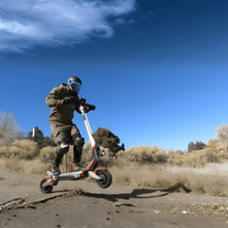 Pilota che salta con il monopattino elettrico Nanrobot N6 su terreno sabbioso