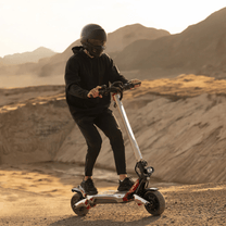 Persona alla guida del monopattino elettrico Nanrobot N6 su terreno sabbioso